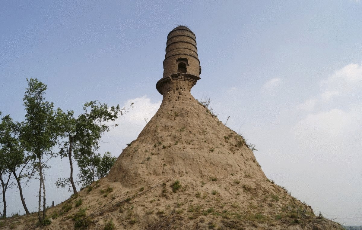 an-ancient-tower-is-seen-balancing-on-top-of-a-dirt-hill-with-its-base-almost-entirely-eroded-along-a-grassland-in-shanxi-province-china-in-july